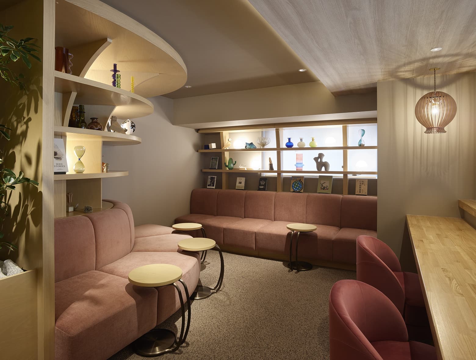 소파, 커피 테이블, 장식품이 진열된 선반 등이 갖춰진 편안하고 현대적인 호텔 휴식 공간.