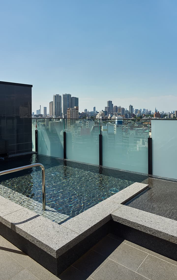 戶外大浴場，採用深色磁磚牆面，可欣賞城市天際線的景觀，並設有大型球形燈具。