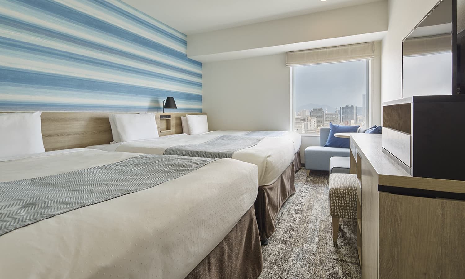 슈페리어 트윈(+추가)룸에는 싱글 침대 2개와 엑스트라 침대 1개, 카펫 바닥, 우드 소재 헤드보드, 패턴 벽지, 좌석 공간, 탁 트인 도시 전망을 감상할 수 있는 넓은 창이 있습니다.