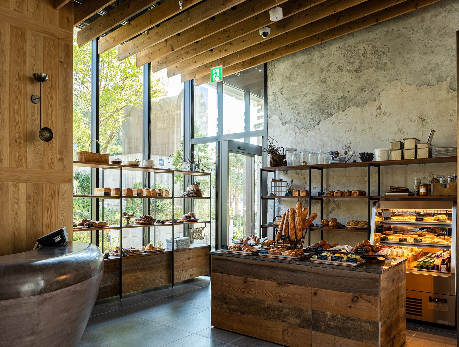 THE GROVE BAKERY 擁有結合現代與質樸的裝潢風格,木質橫梁、大片窗戶,以及陳列各式烘焙點心如麵包、糕點和蛋糕的層架。