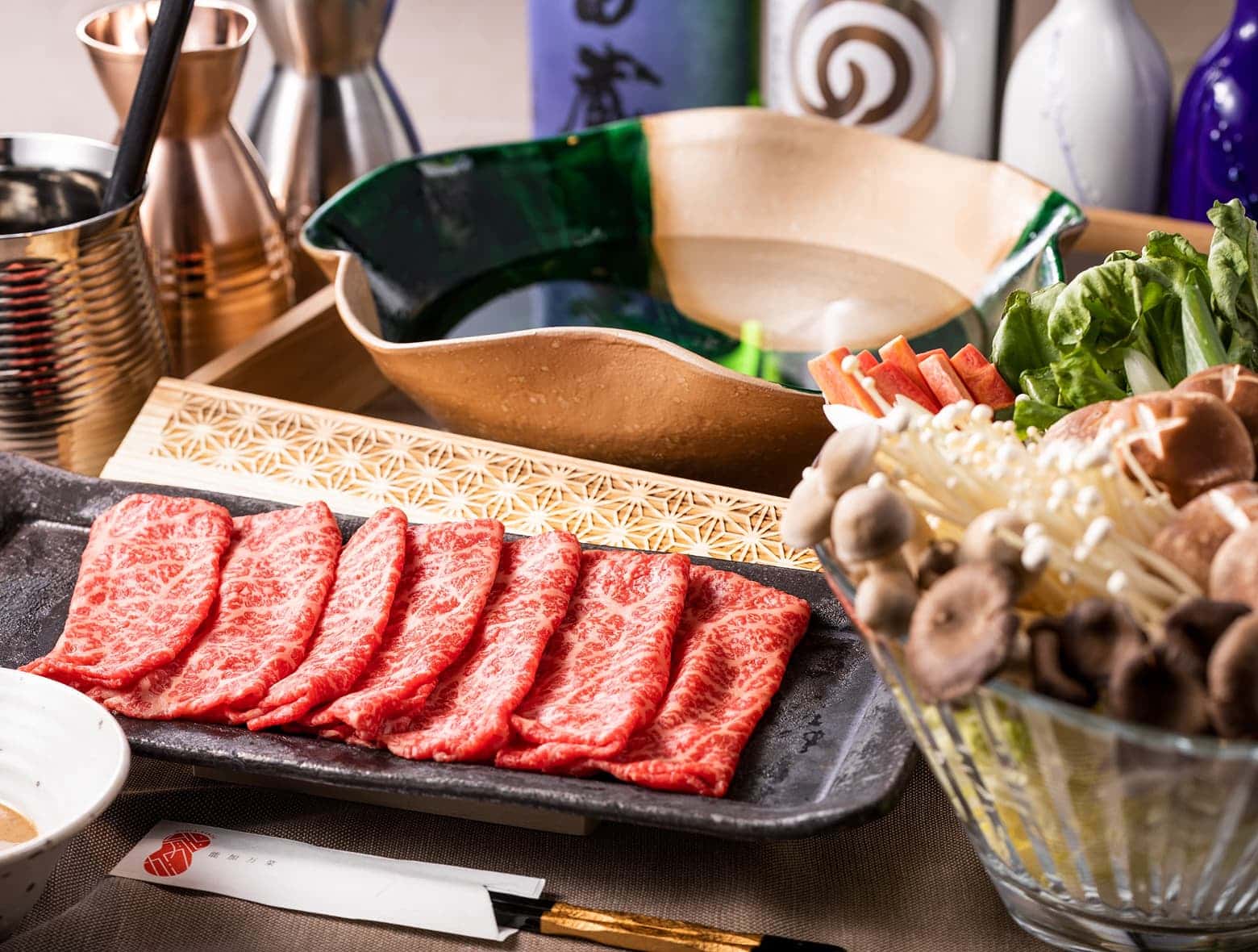 마블링이 좋은 얇게 썬 고기, 모듬 채소, 육수가 담긴 냄비.