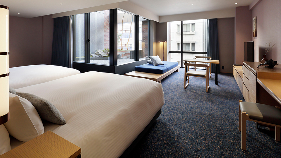 The Junior suite , 2 beds Queen room, with two queen beds, features a spacious and bright interior overlooking a tranquil Japanese garden.