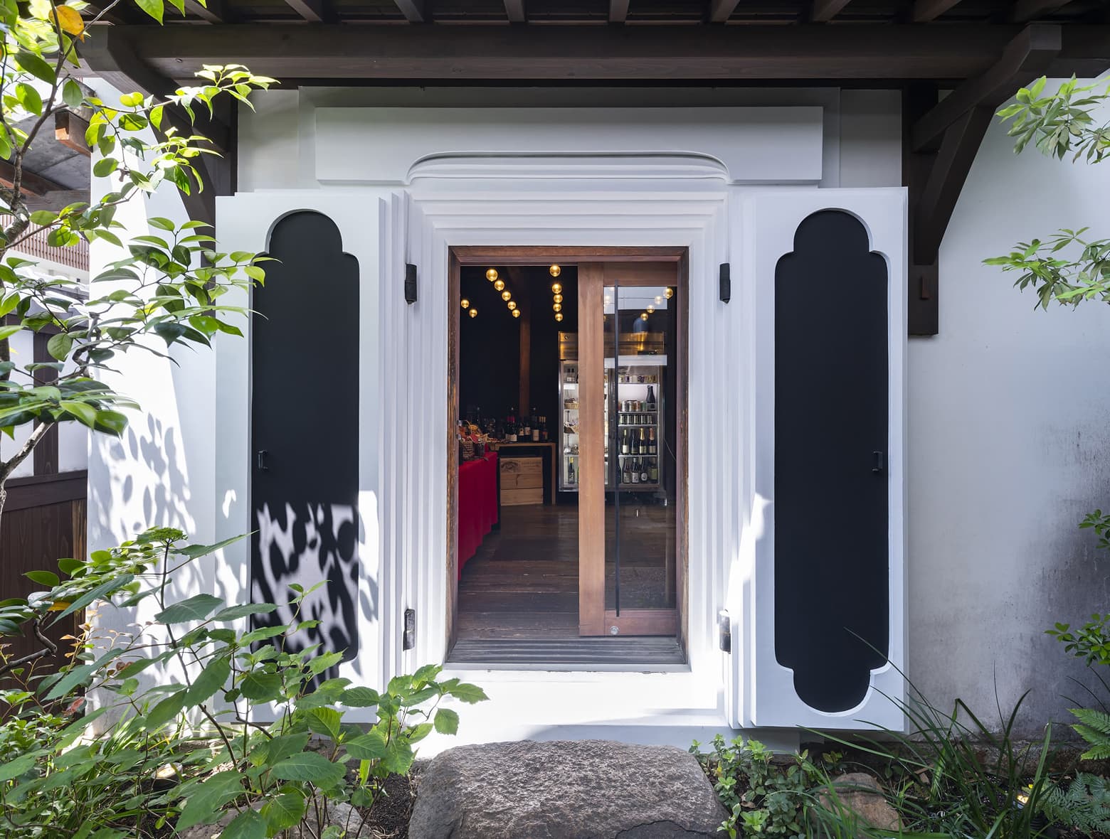 호텔 내 기념품 숍인Sanga Kura Market 입구. 흰색과 검은색으로 된 문이 활짝 열려 있고 주변에 녹색 식물이 있는 모습.