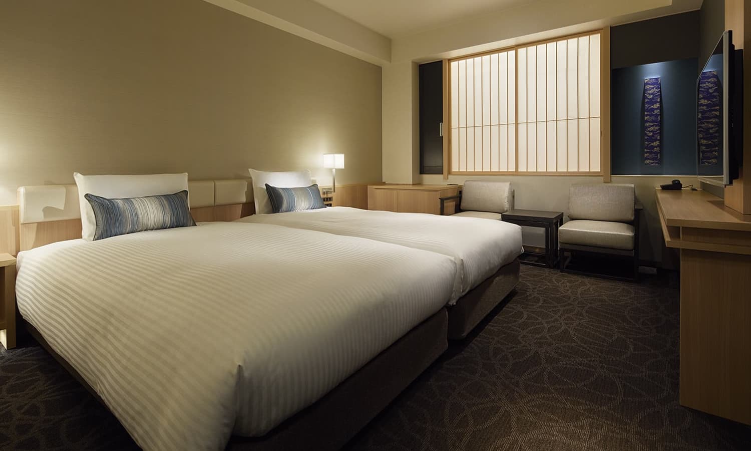 스탠다드 트윈룸에는 싱글 침대 2개, 전통 일본식 쇼지(일본 전통 가옥에서 볼 수 있는 미닫이 문 또는 창으로 나무 틀에 일본 전통 종이를 바른 형태) 창 가까이의 좌석 공간, 목재 가구가 있습니다.