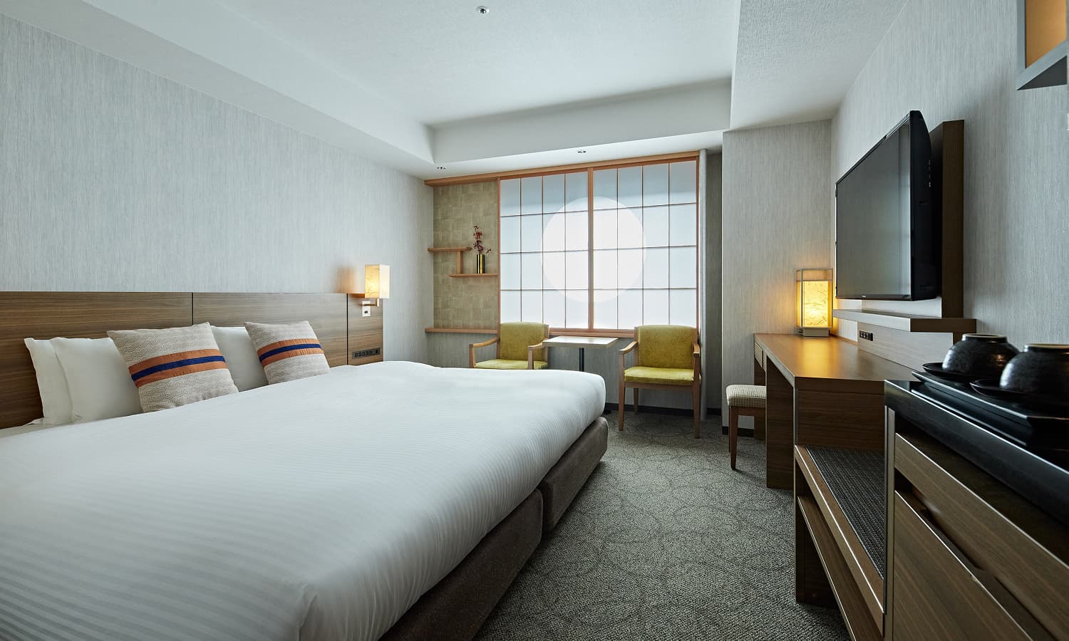 스탠다드 와이드 킹룸에는 넓은 킹사이즈 침대, 밝은 색의 패턴 카펫, 쇼지(일본 전통 가옥에서 볼 수 있는 미닫이 문 또는 창으로 나무 틀에 일본 전통 종이를 바른 형태) 창, TV가 놓인 목재 책상 공간이 있습니다.
