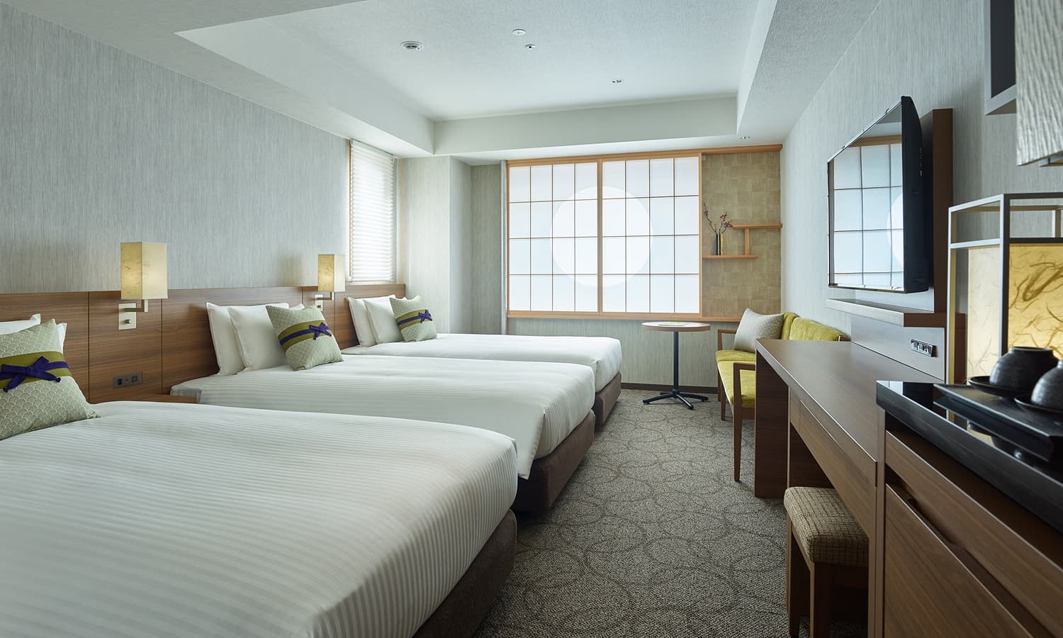 스탠다드 트리플룸에는 싱글 침대 3개, 밝은 색의 패턴 카펫, 쇼지(일본 전통 가옥에서 볼 수 있는 미닫이 문 또는 창으로 나무 틀에 일본 전통 종이를 바른 형태) 창, TV가 놓인 목재 책상 공간이 있습니다.