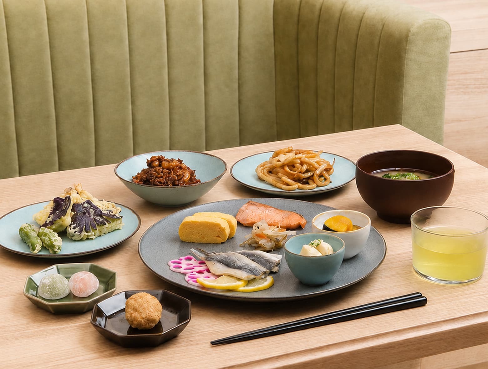 “花园咖啡厅”的餐桌上摆放着各色日式料理,包括蔬菜天妇罗、团子、乌冬面、鸡蛋卷、味噌汤和鱼类。