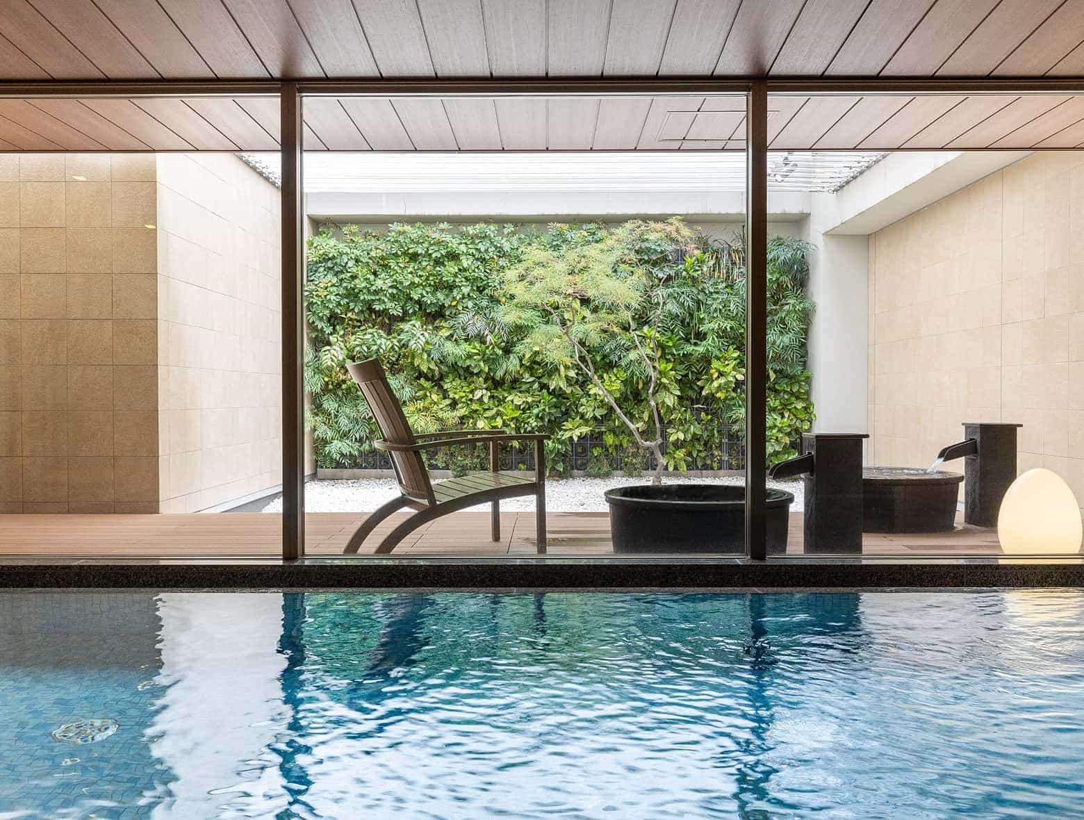 A close-up of our large public bath, showcasing expansive glass windows, comfortable seating, and serene garden features.