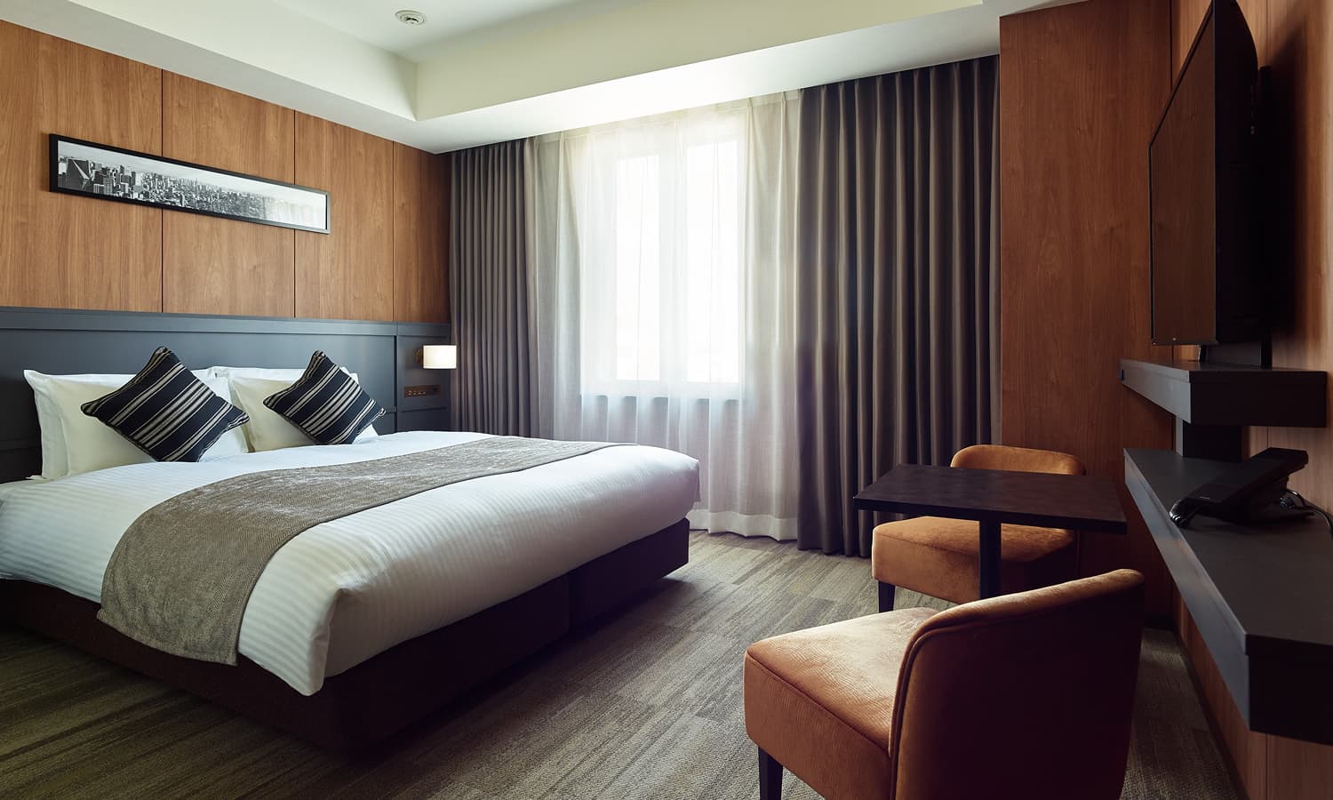 高级房 - Queen配有一张大号床、木质镶板、一张带椅子的小桌和一台壁挂式电视。