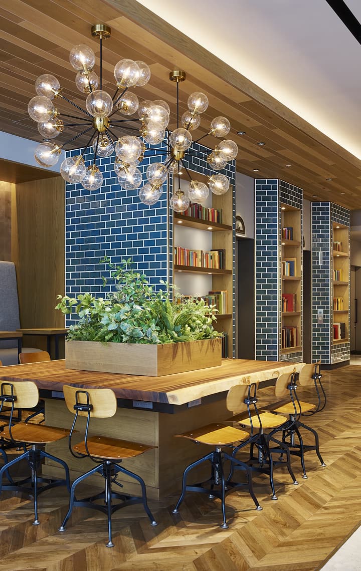 时尚的酒店大厅配有大型共享木桌及嵌入砖砌立柱中的书架。