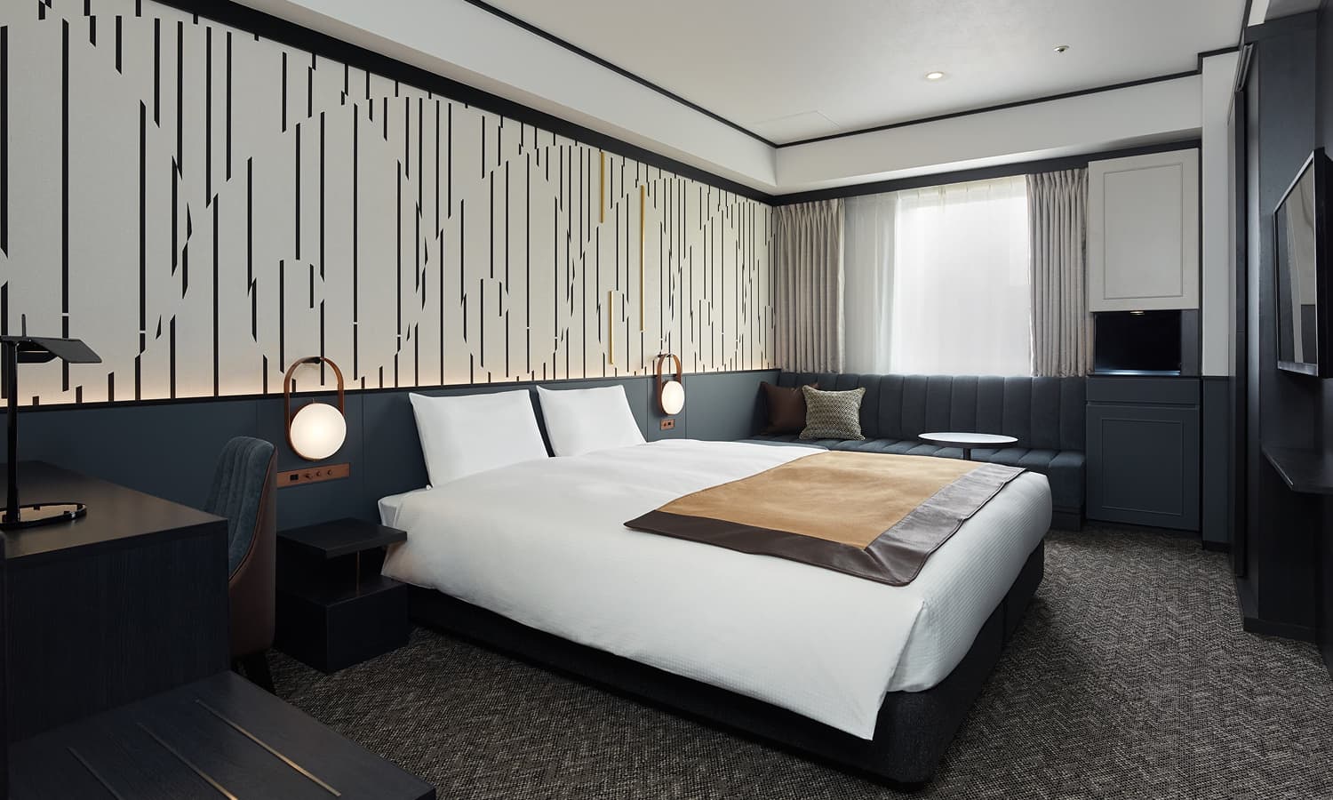 高級客房 - King,備配有一張King size大床、一張沙發,床後方引人注目的黑白直紋圖造型牆。