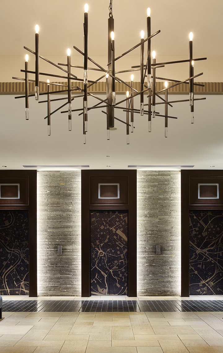 現代優雅的飯店大廳,深色木門質感的電梯為一大特色,還有四張藍色天鵝絨沙發。