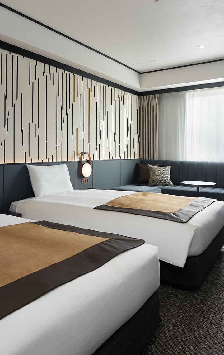 高級雙床房(東京鐵塔觀景房),配備有兩張單人床、一張沙發,床後方引人注目的黑白直紋圖造型牆。