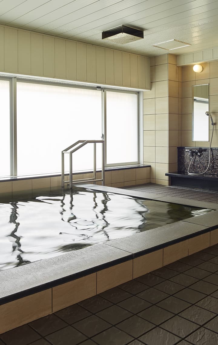 寧靜的大浴場有一個寬敞的長形浴池、一整排淋浴間和一扇明亮的窗戶。