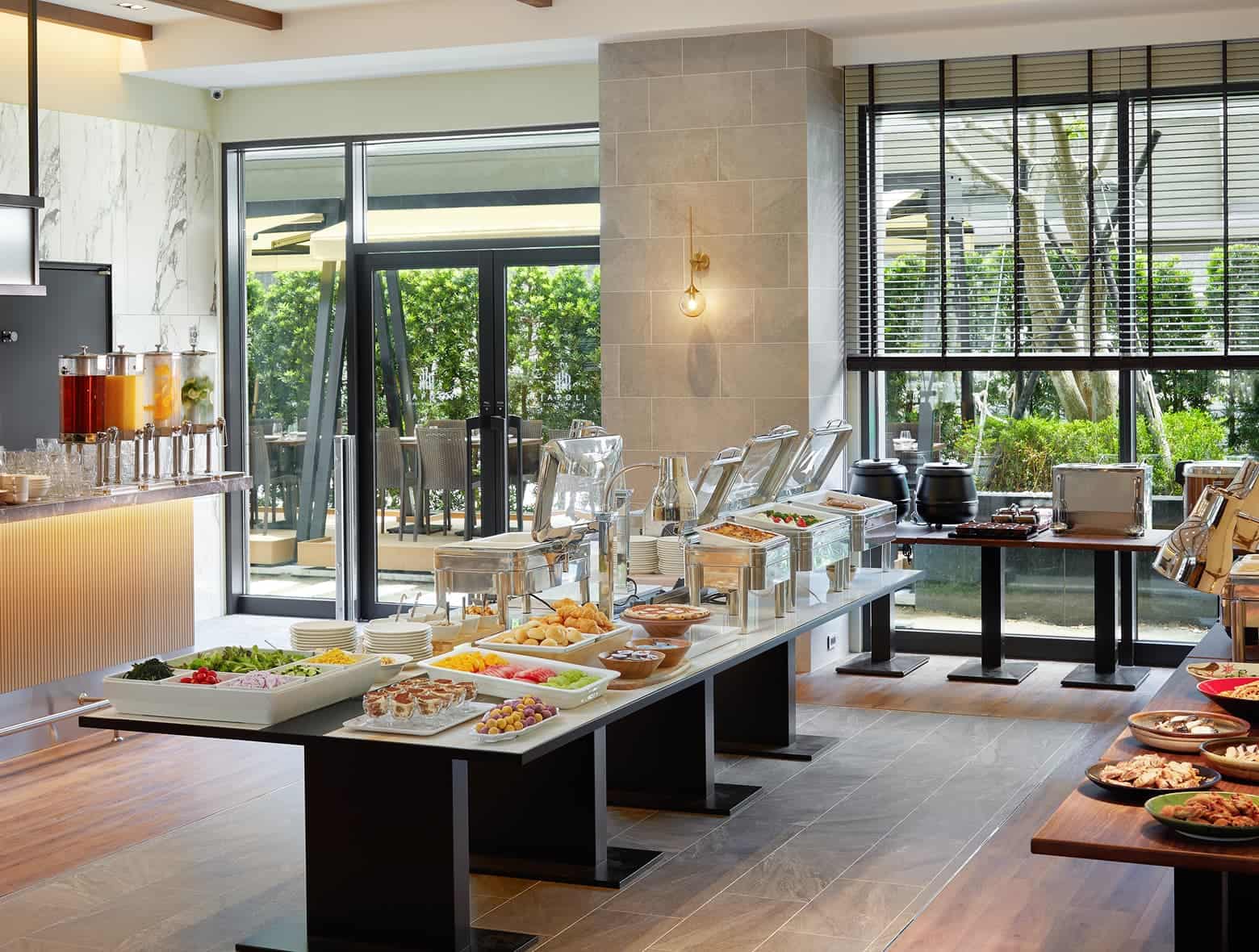 여러 가지 신선한 샐러드, 과일, 따뜻한 요리 및 음료 디스펜서가 있는 호텔 조식 뷔페.