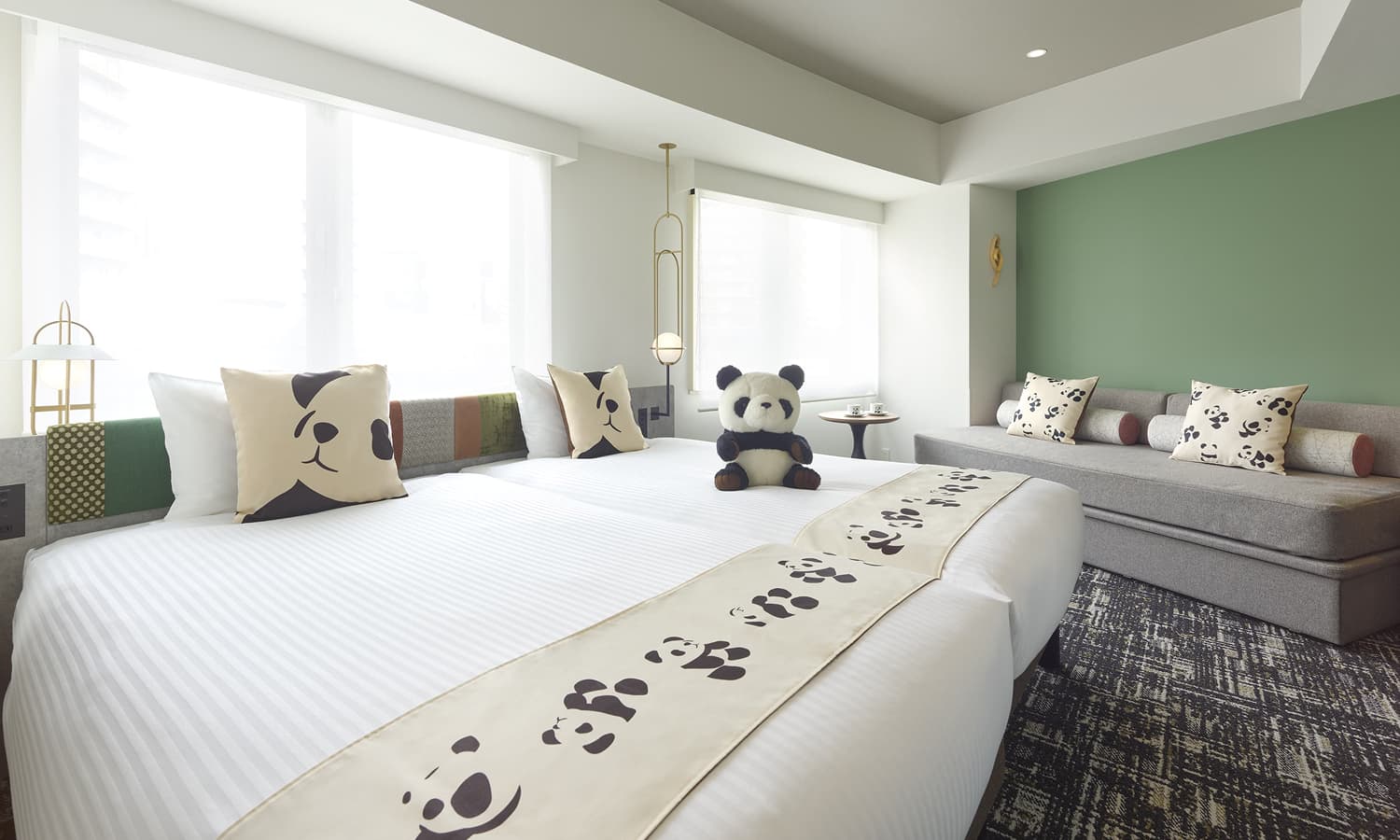 판다 슈페리어 트윈(+소파베드)룸은 싱글 침대 2개, 소파베드, 판다 무늬 쿠션, 판다 무늬 침대 러너, 은은한 녹색 포인트 벽을 갖추고 있습니다.