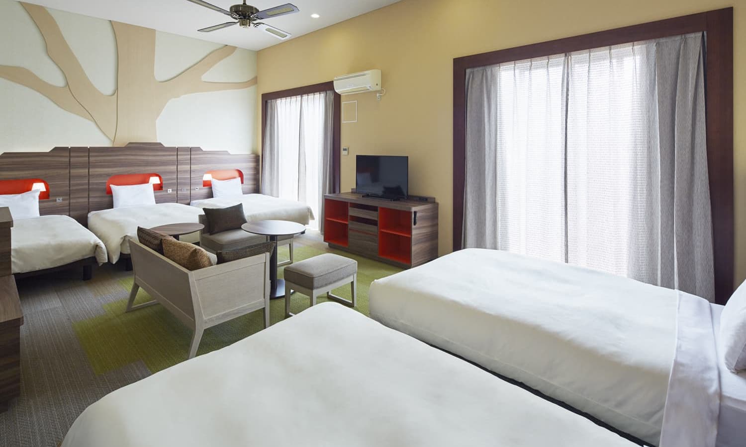 The Executive, 5 beds, Terrace room features five single beds, a tree-themed wall mural, and a seating area, and two windows for natural lighting.